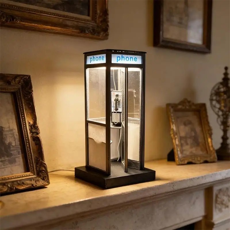 A miniature British phone booth reimagined as a warm night light — instantly recognizable, visually charming, and actually useful bedside.