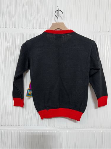 Black and red NWT vintage 1992 Barney Christmas sweater with red cuffs, hanging on wooden hanger against white textured wall.