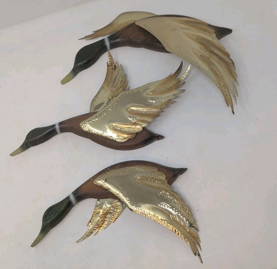 Three-piece vintage wood and brass flying mallards wall set — a classic MCM sportsman's decor staple that's charming, camp, and genuinely collectible.