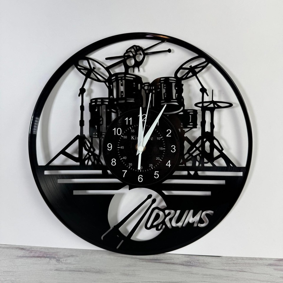 A vinyl record repurposed into a drum-kit silhouette wall clock — clever upcycled design that's both functional and a music-room statement piece.