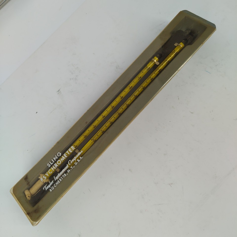 A real brass-and-glass sling psychrometer — the kind of analog weather instrument that looks like it belongs in a Victorian meteorology lab.