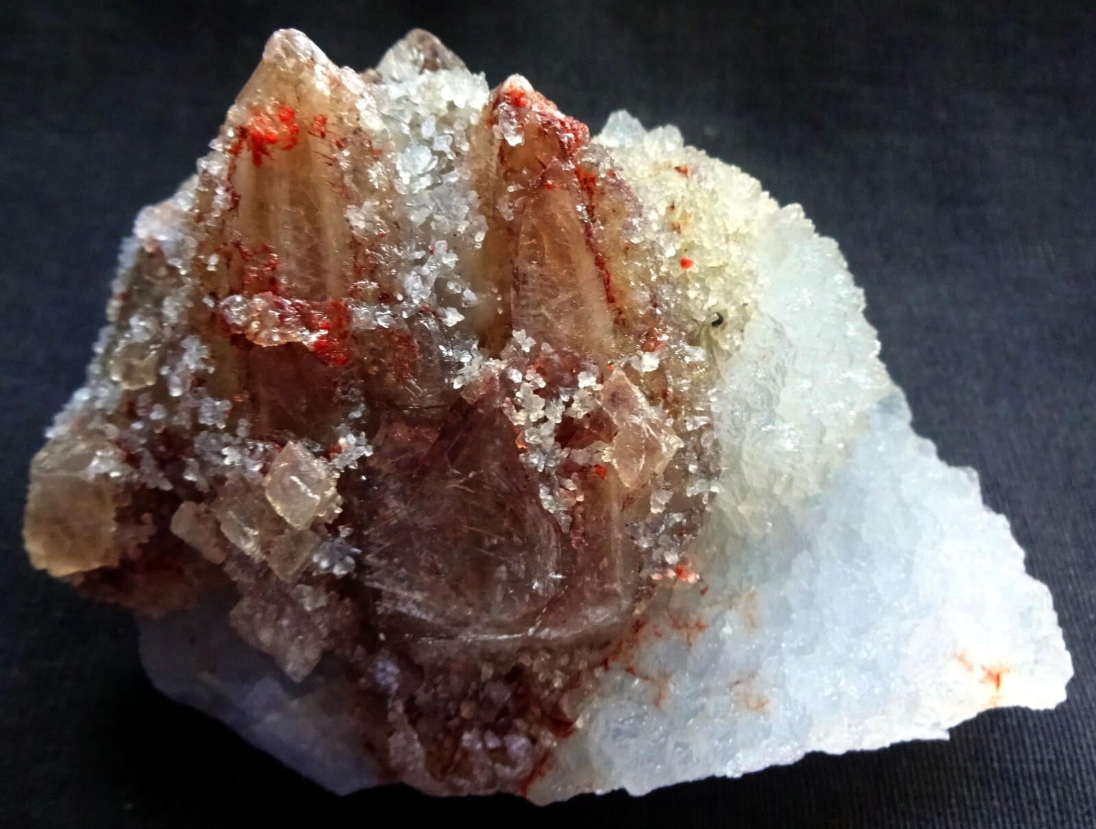 Calcite crystals with red fluorite dots on quartz matrix mineral specimen