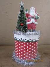 Santa with tree atop decorated box