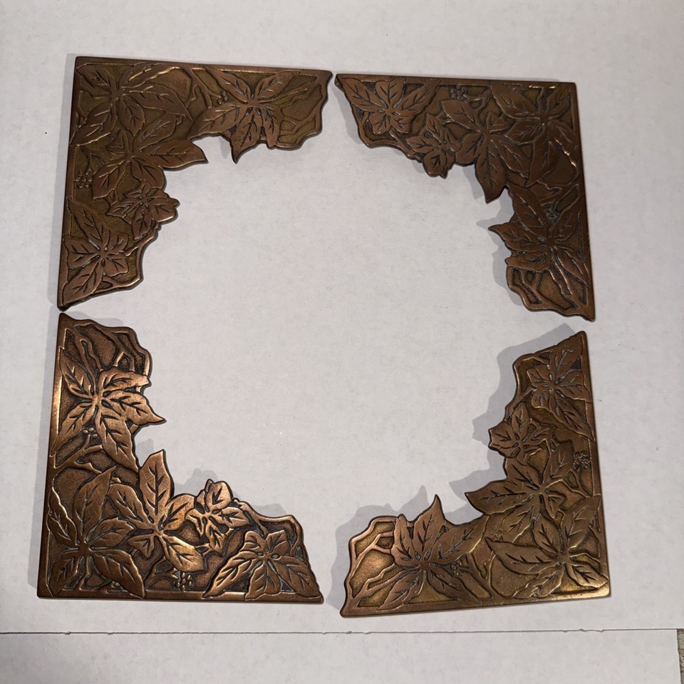 Antique brass blotter corners etched with Virginia Creeper leaf patterns — a hyper-specific Victorian desk detail that almost no one knows exists anymore.