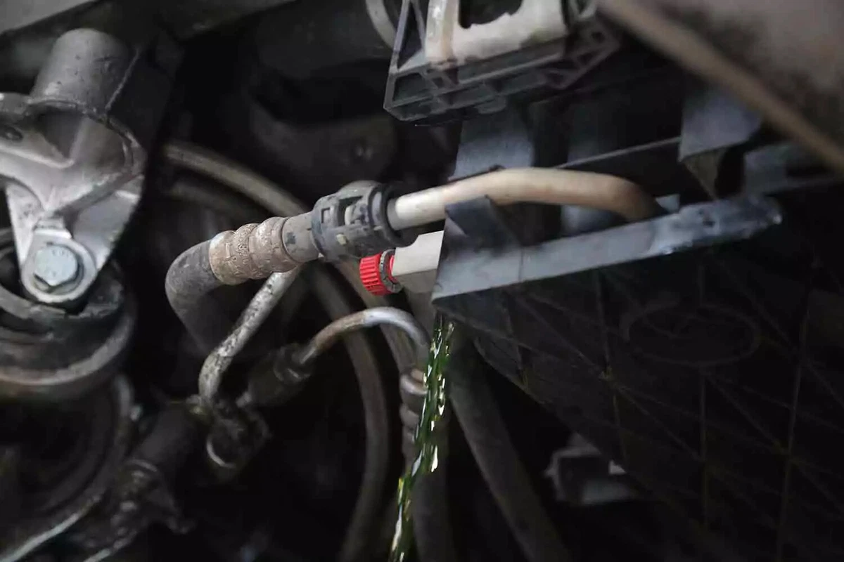 Green coolant liquid drains from a vehicle.