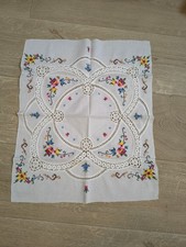 Centrotavola in cotone bianco con ricamo a punto croce e dettagli all'uncinetto.
