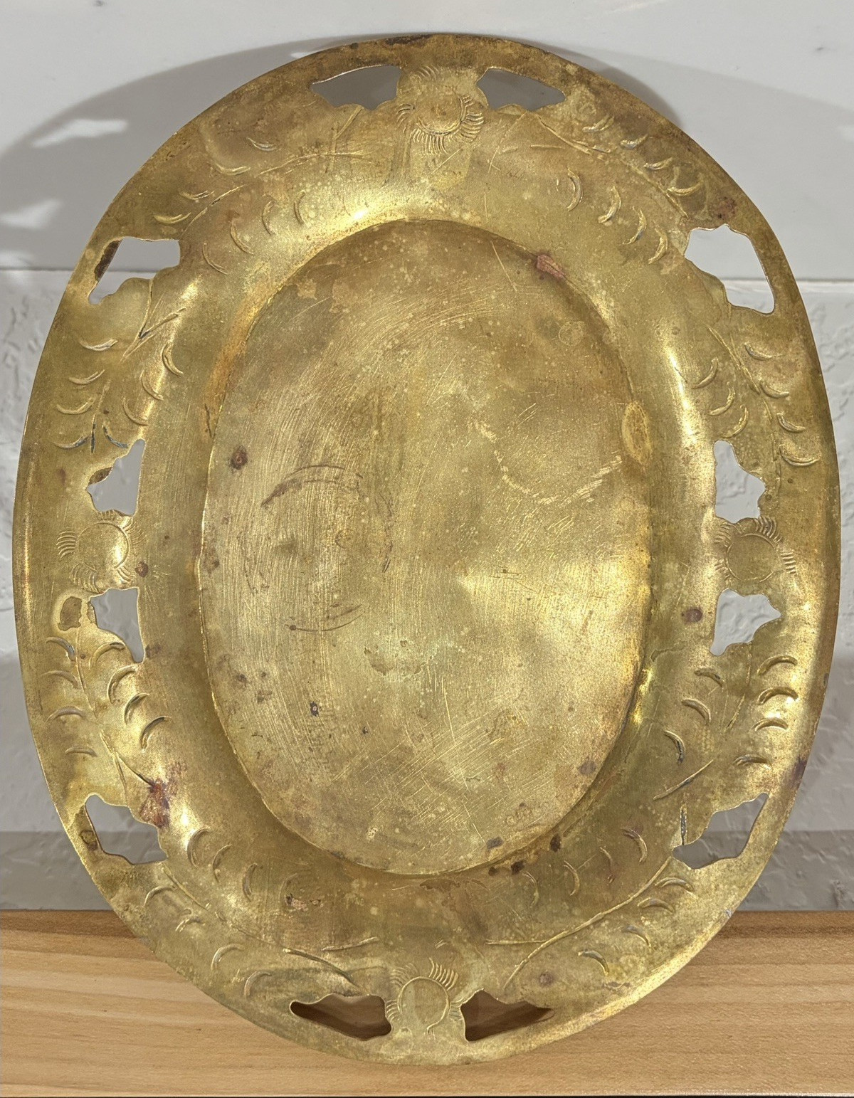 Oval brass serving tray with an etched floral design.