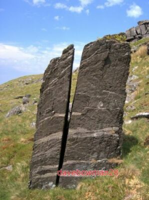 FOTO GESPALTENER FELSBROCKEN AN DER SEITE VON MOEL DDINAS DER HANG SCHEINT RUTSCHIG ZU SEIN