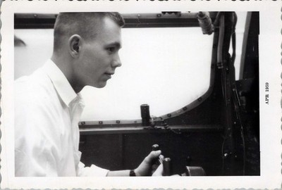 1959 Closeup Photo of Young Man Adjusting Controls Inside Aircraft Cockpit