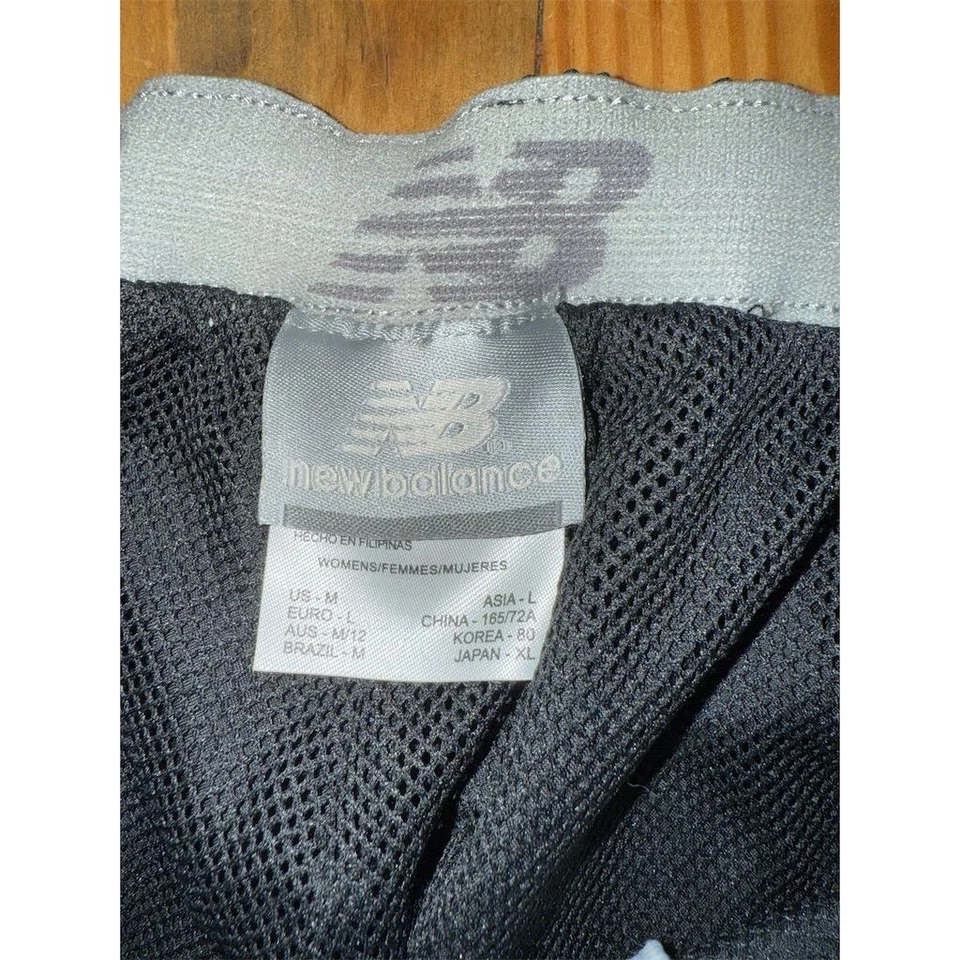 Pantalones cortavientos New Balance negros para mujer M informales pierna recta atletismo Foto 2 de 4
