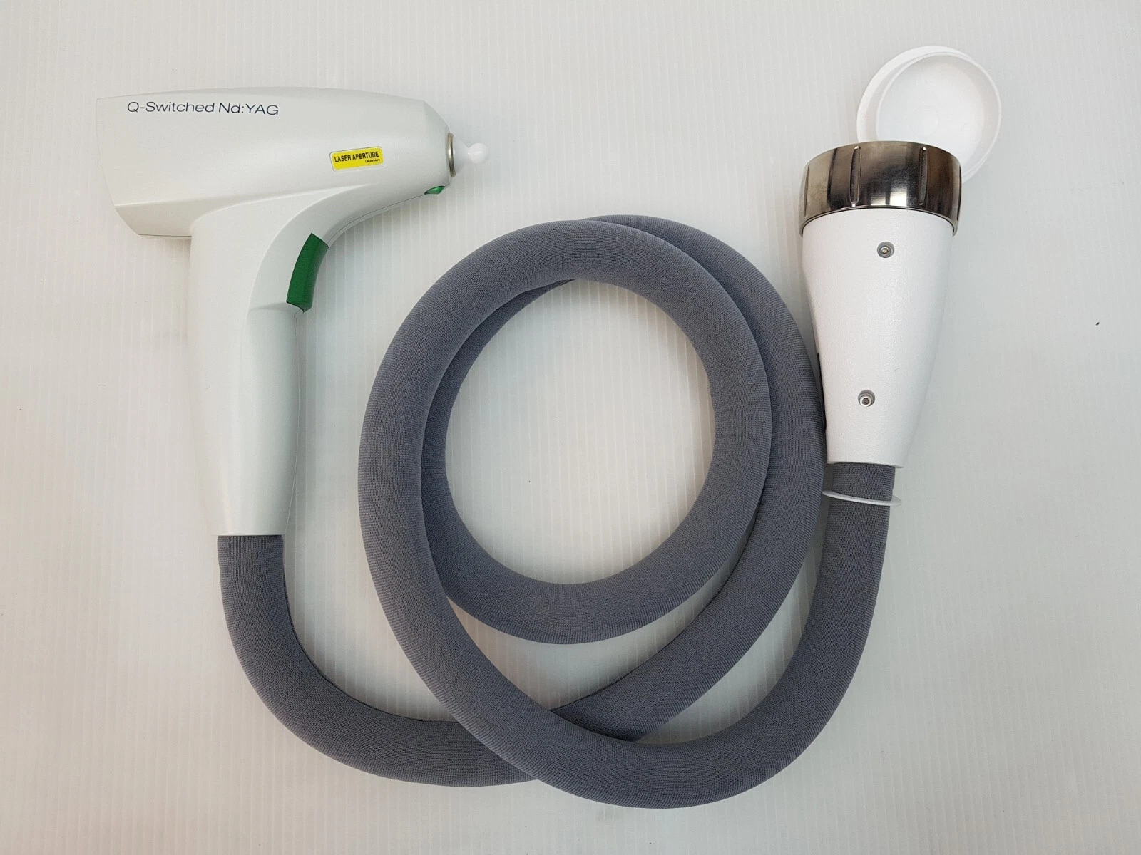 Lumenis M22 Q-Switched Nd:YAG treatment head with grey umbilical and connector