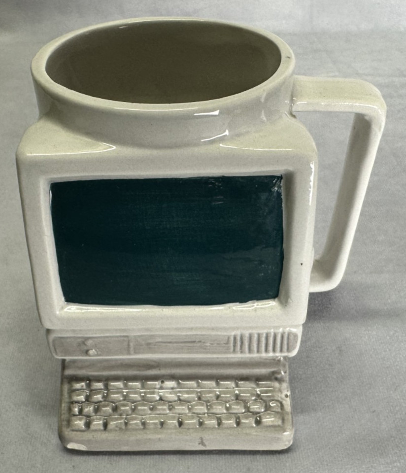 A 1993 ceramic mug shaped like a chunky CRT computer monitor — peak 90s nostalgia in drinkable form.