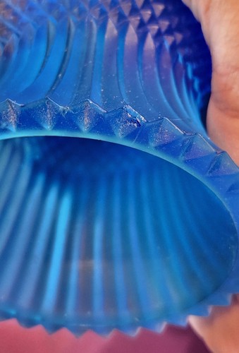 Close-up of cobalt blue glass tulip votive candle holder with vertical ridges, revealing imperfections in the glass.