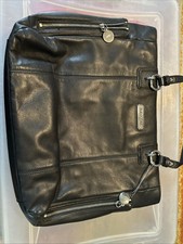 Coach black leather tote features distinctive silver-tone