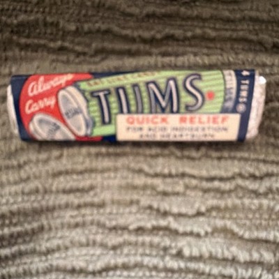 Roll of Tums antacid tablets, specifically a 4-pack from the Lewis-Howe Company