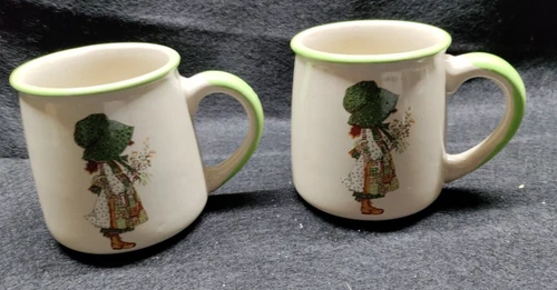 LOT 2 VINTAGE 1978 HOLLY HOBBIE COFFEE CUPS MUGS IVORY W/ GREEN TRIM CERAMIC