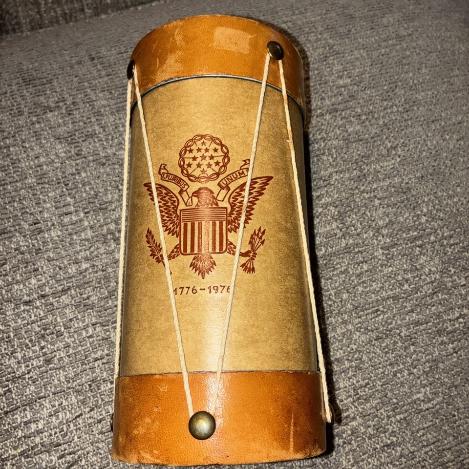 A leather-wrapped drum-shaped bicentennial flask from 1976 is peak Americana novelty — historical, functional, and utterly specific.