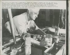 1957 Press Photo Tracey Reynolds Lowers Can of Corn Bound for Irradiation, Idaho
