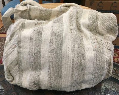 Purse drawstring shoulder bag features beige and white striped fabric