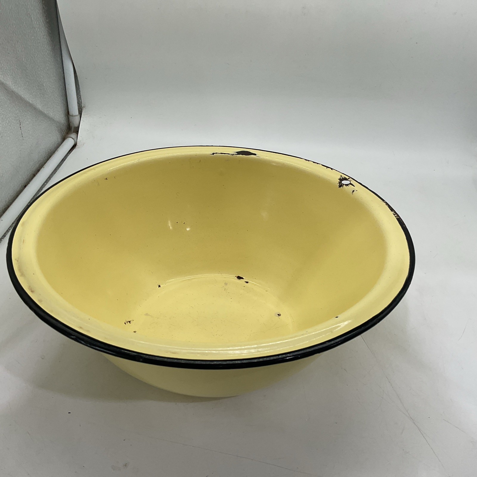 Large yellow speckled enamelware bowl with black rim