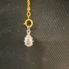 Vintage Joan Rivers silver-toned egg pendant featuring embossed details & stone