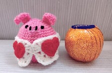 Image of Crocheted chocolate orange cover pig in heart blanket. Handmade Easter gift