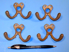 FOUR VINTAGE ODD METAL COAT HOOKS
