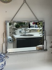 Vintage chrome mirror with a tubular metal frame and hanging chain, 1930s–1950s.