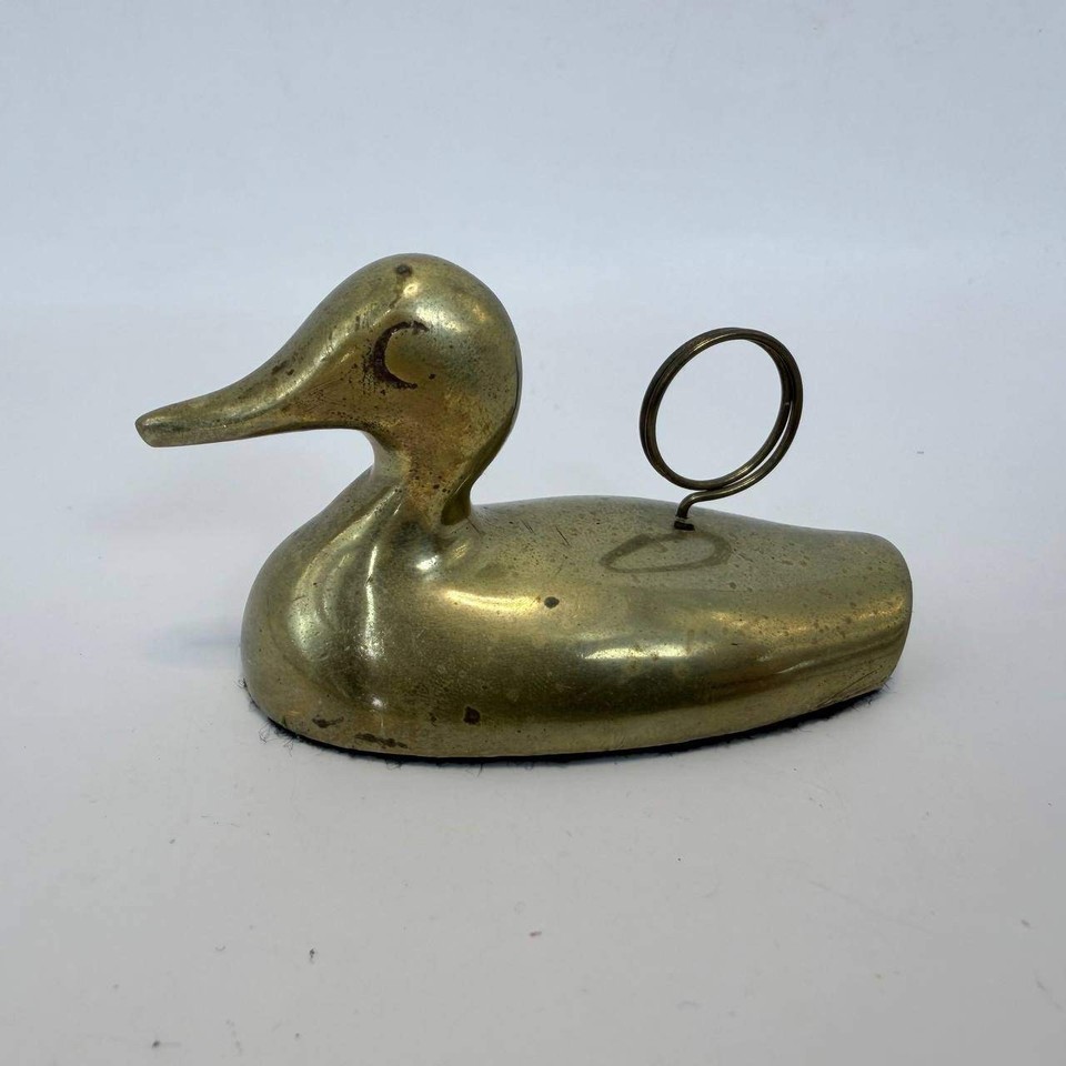 A chunky brass duck that holds your memos AND your photos — absurdly charming and deeply giftable.