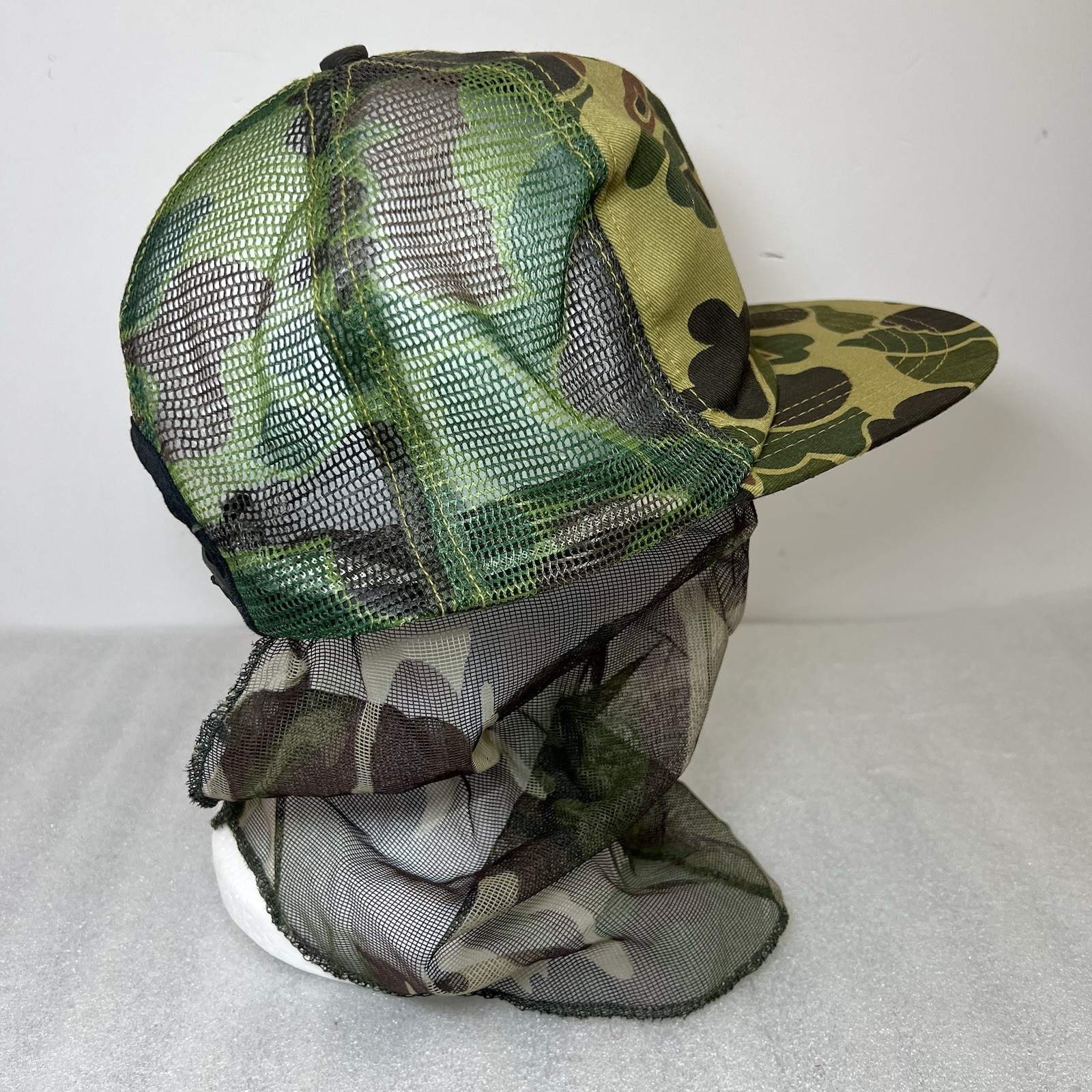Green and black camo snapback hat with mesh front and dark green leaf pattern on top, USA made.
