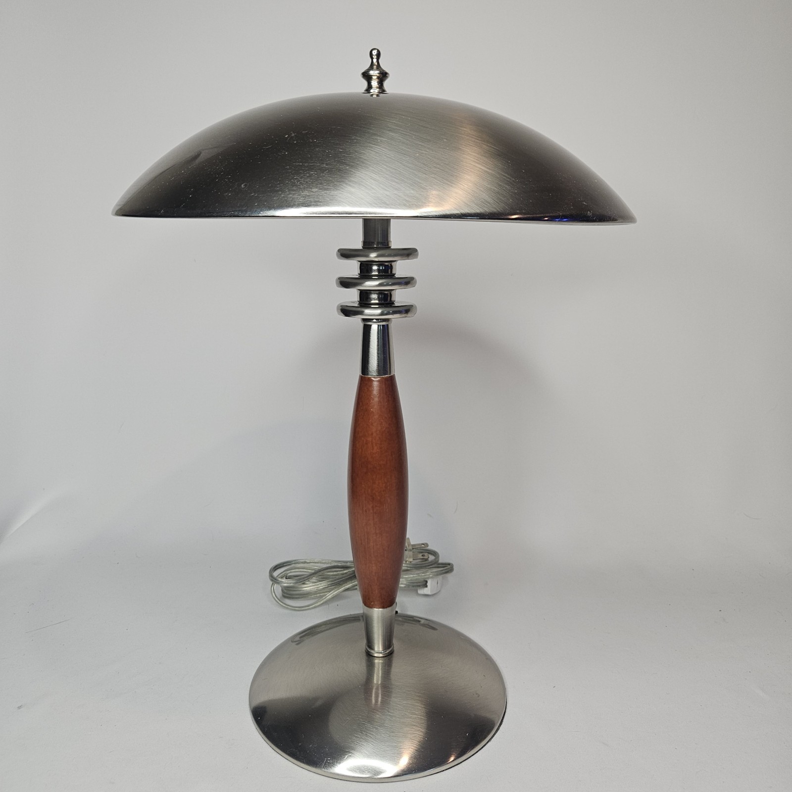 Chrome dome-shade table lamp with a wood hourglass stem and round chrome base, shown cut out on white.