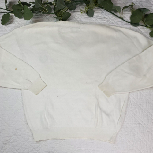 White VTG Christian Dior men's V-neck sweater with long sleeves and crew neckline, made in USA, on floral fabric background.