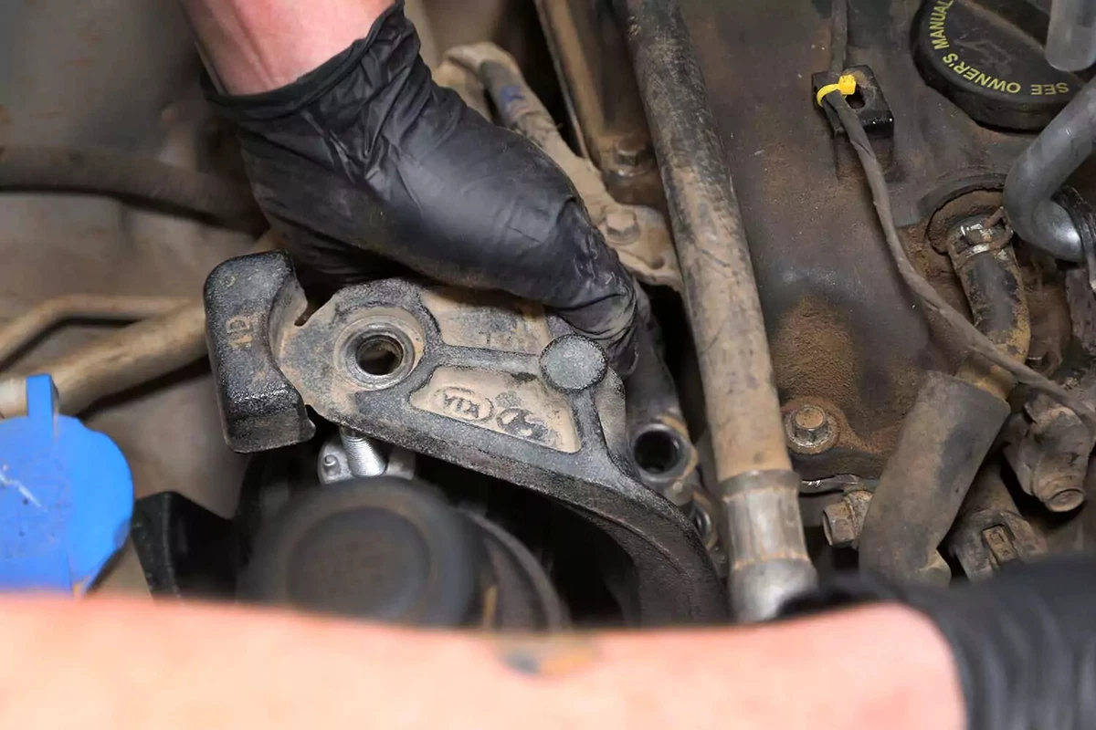 Mechanic reinstalling the intermediate bracket on the engine and motor mount.