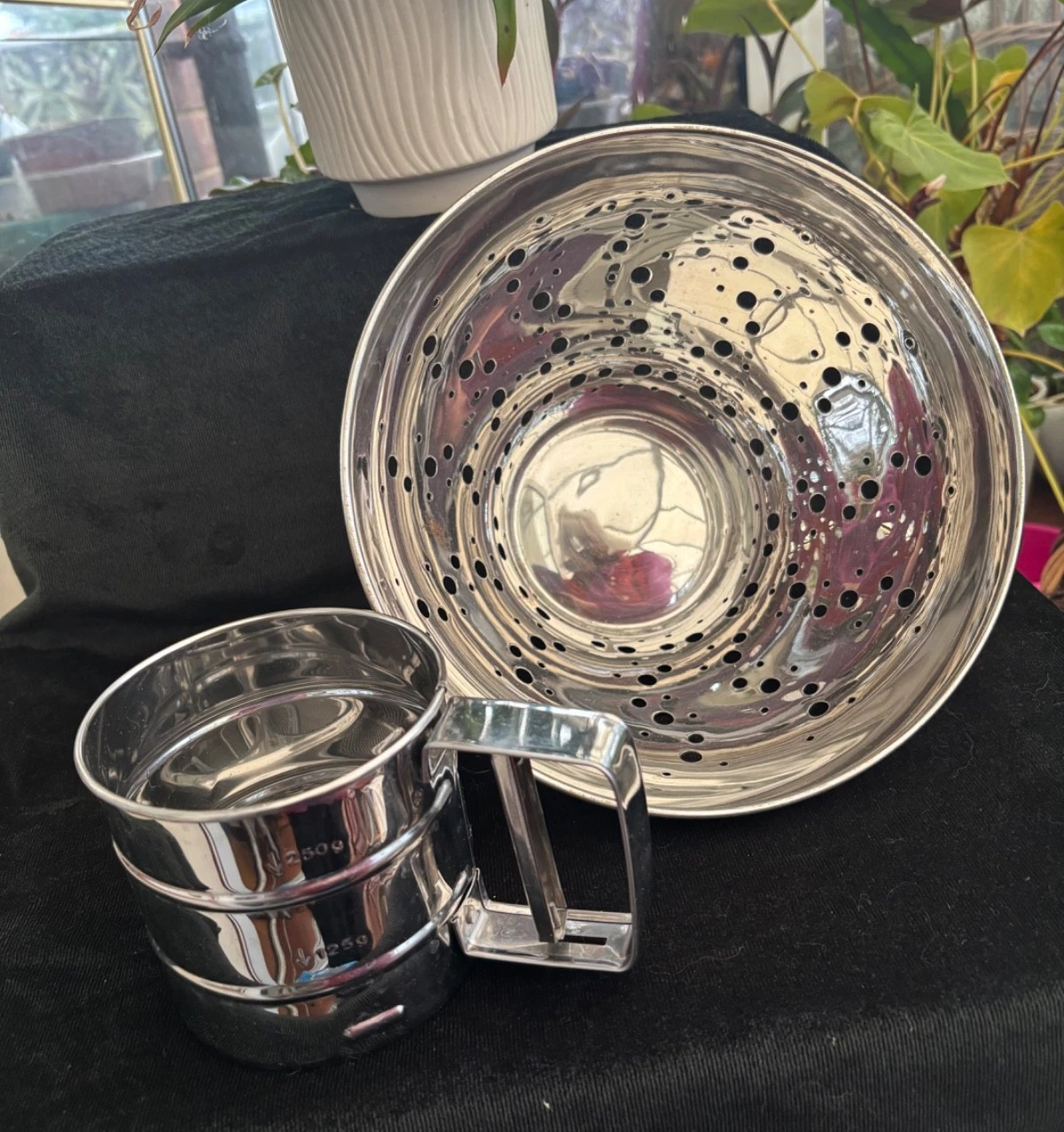 Colander and hand-operated flour sifter/shaker, both stainless steel