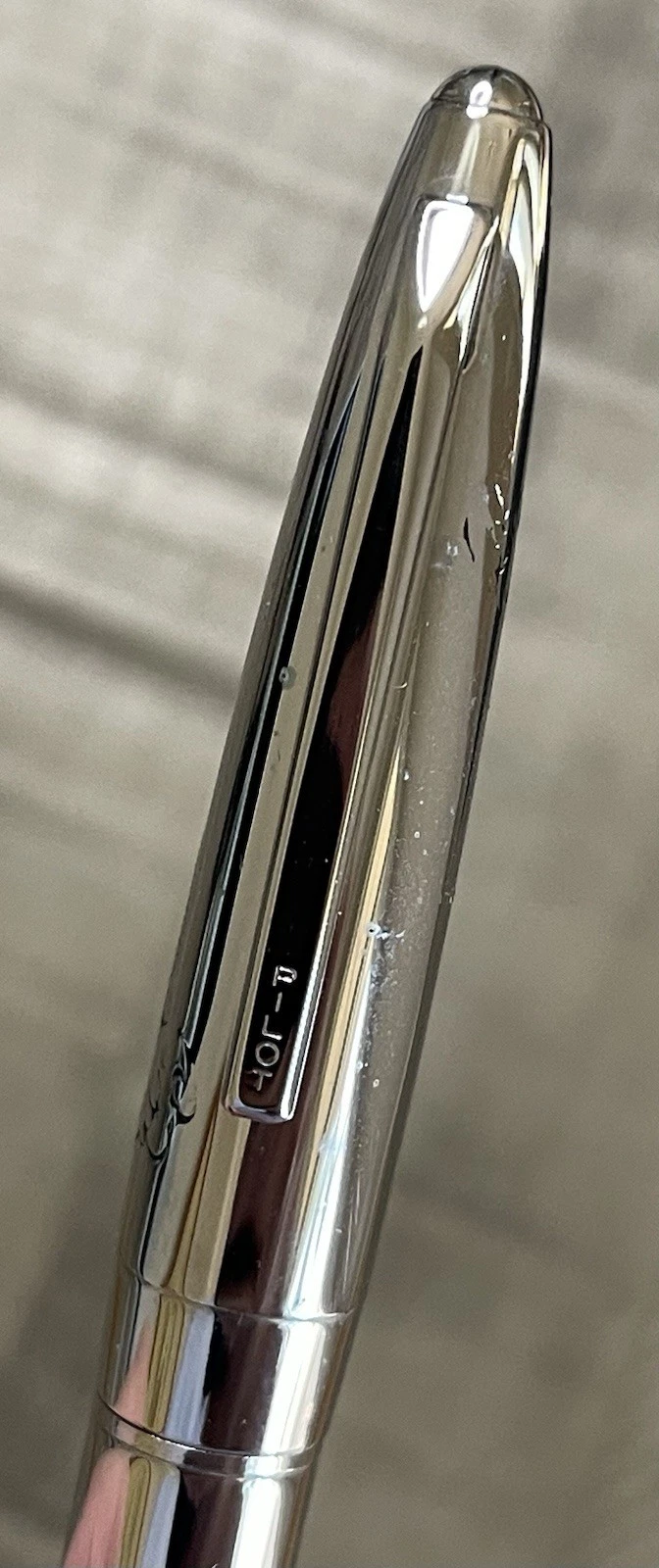 Chrome-plated Pilot Namiki fountain pen with silver body, black nib, and engraved oval logo on side.