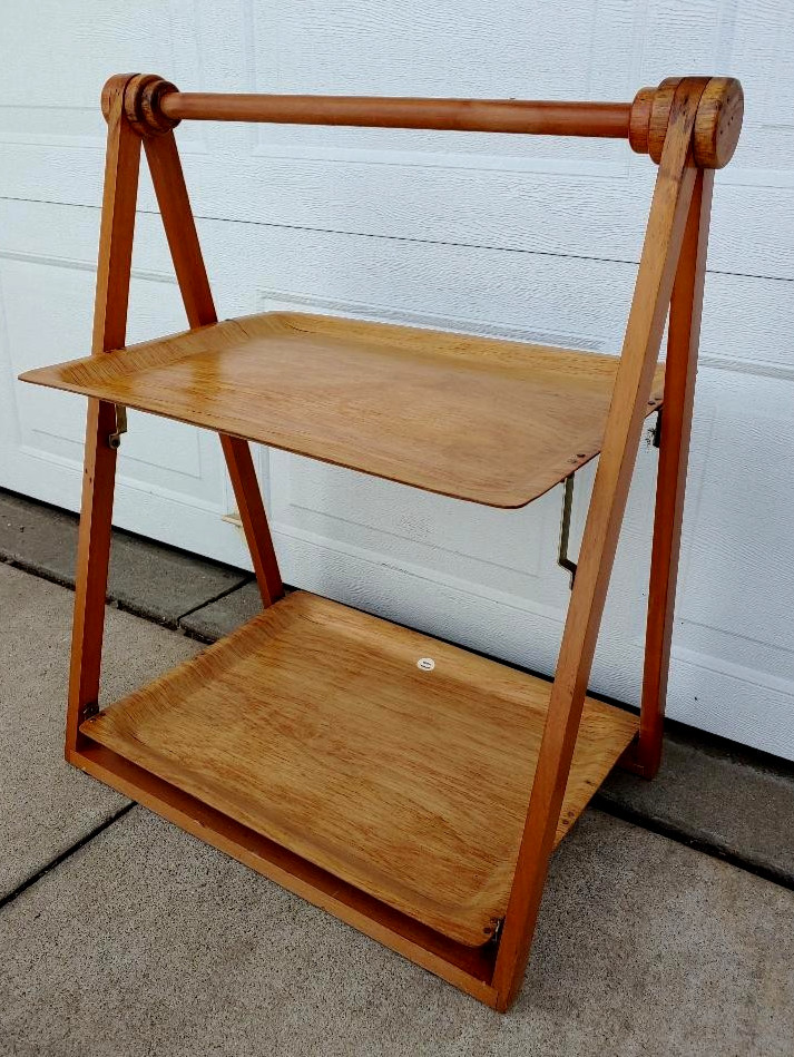 A collapsible two-shelf Swedish MCM wood bar cart that folds flat — Scandinavian design ingenuity from the mid-century era at its absolute finest.