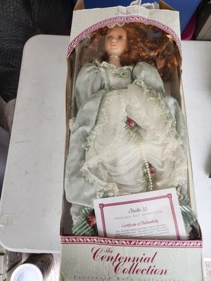 Centennial Collection'' porcelain doll featuring curly red hair and a green...