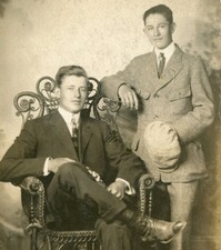 HANDSOME YOUNG MEN POSED WITH ORNATE WICKER CHAIR. TONED SILVER PRINT, 1920s.