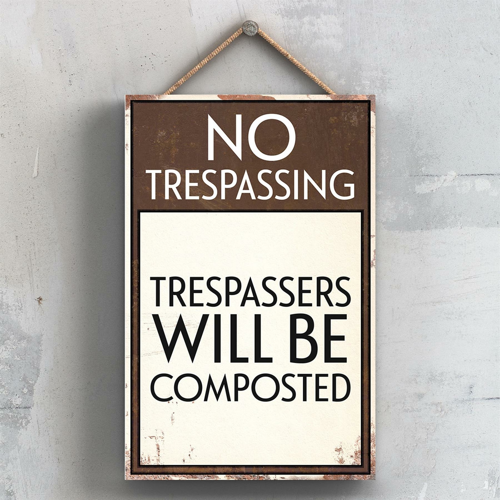 TRESPASSERS WILL BE COMPOSTED TYPOGRAPHY SIGN PRINTED ONTO A WOODEN PLAQUE
