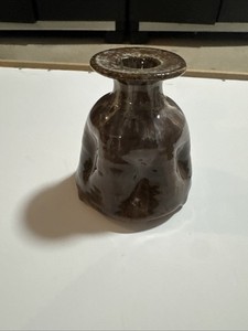 brown ceramic vase features a distinctive wide, flat rim and an organic, 