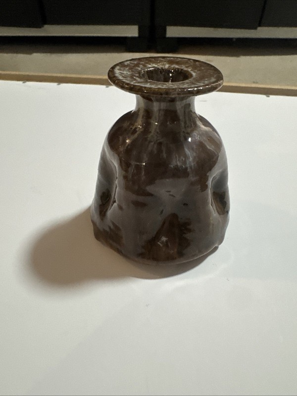 brown ceramic vase features a distinctive wide, flat rim and an organic, 
