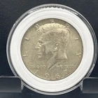 1967 Kennedy half dollar coin in capsule.