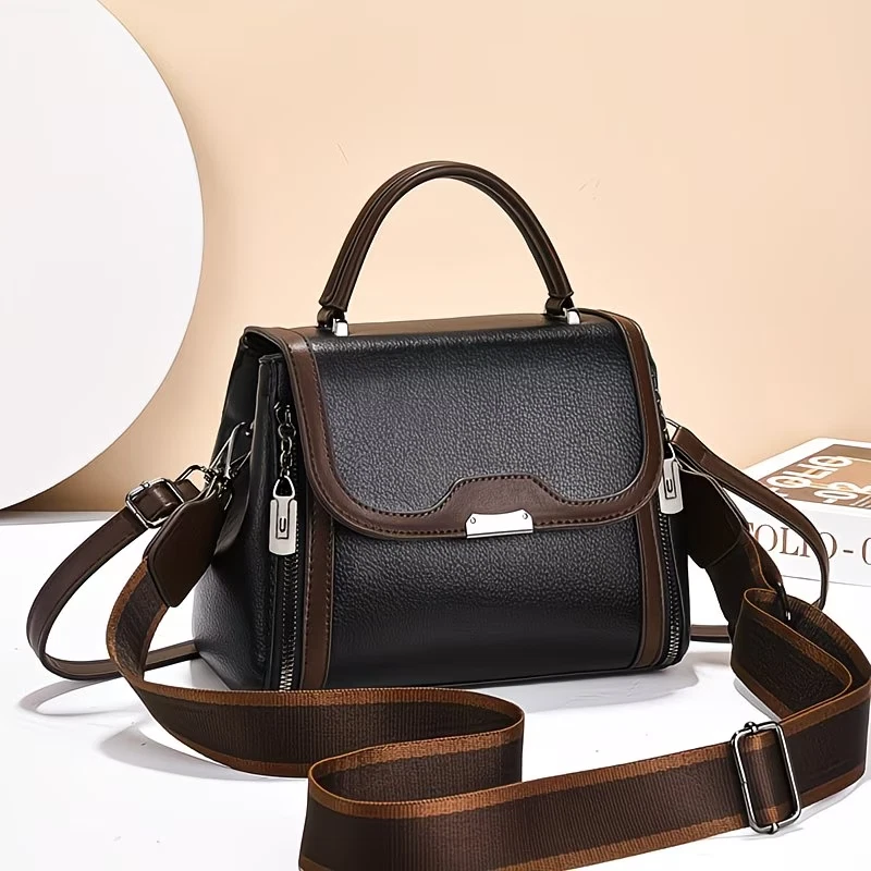 A modern handbag with a classic design in contrasting colors, featuring two adju