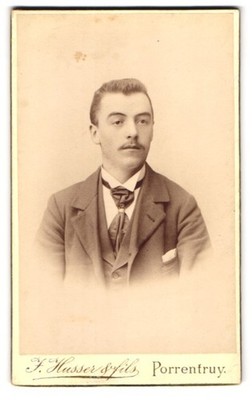 Fotografie J. Husser & fils, Porrentruy, Portrait junger Herr im Anzug mit Kraw 