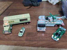 7 Piece Hess Lot. With 2 tractor Trailer Trucks, 2 Race Cars, And A Helicopter.