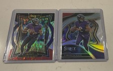 2-RAVENS LAMAR JACKSON ‘23 SELECT RED/YELLOW DIECUT, ‘SELECT BLACK/RED CONCOURSE
