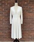 White vintage 70s midi prairie dress with scalloped lace neckline, fitted bodice, and flared sleeves displayed on mannequin.