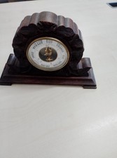 vintage aneroid barometer housed in a decorative, carved wooden frame