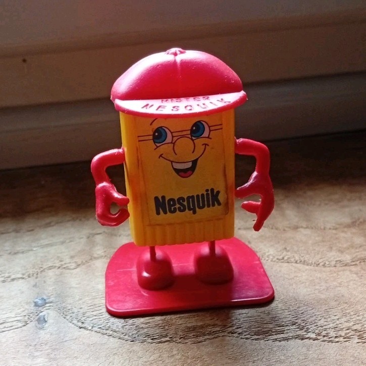 Nesquik personaggio in plastica giallo/rosso con cappello rosso, base e braccia