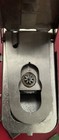 Silver metal Singer buttonholer with visible gear and spindle, showing interior of the mechanism.